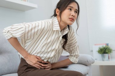 stomach ache. Asian women have abdominal pain, indigestion, gastritis, menstrual cramps, flatulence, diarrhea, distention, colon cancer, belly inflammation problem, suffer food poisoning, abdomen