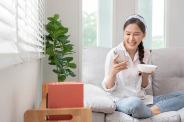 Asyalı güzel kız mutlu bir şekilde gülümsüyor. Sosyal medya, eğlence, hobiler, tatilde iyi hissetmek için cep telefonu kullan. genç bayan başarısı, reklam panosu, reklam, çekici, ifade, pozitif