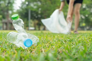 Dünyayı kurtar. Gönüllü olarak parktaki çöpleri topluyor ve plastik şişeler zarar görmemesini sağlıyor. Dünya, Çevre, Yeşilci Gezegen, küresel ısınmayı azaltın, Dünya 'yı ve kirliliği kurtarın.