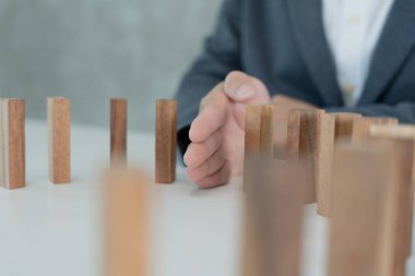 Domino 'yu elleri olan sigorta korur. İş adamı elleri iş krizinde domino taşlarının düşmesini durdurur. işletme risk denetimi ve planlama ve işletmeler sigorta işletmelerini önlemek için stratejiler.