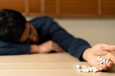 Asyalı erkek aşırı dozda hap kullanıyor, stresli, üzgün, uyuşturucu bağımlısı, uyuşturucu bağımlısı, hasta, sağlıksız, mutsuz, intihar, depresyonda veya umutsuz, uyuşturucu bağımlısı, yaşam ve aile sorunları, motivasyonsuz
