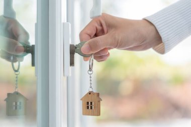 Landlord key for unlocking house is plugged into the door. Second hand house for rent and sale. keychain is blowing in the wind. mortgage for new home, buy, sell, renovate, investment, owner, estate