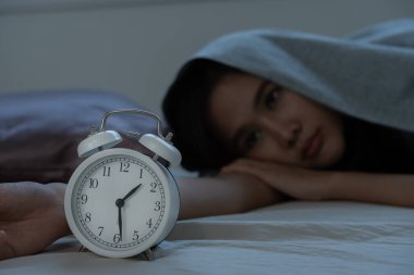 Asyalı kadın geç saatlere kadar uyumaya çalışıyor uykusuzluk çekiyor, uykusuzluk çekiyor ya da bir kabusta korkuyor üzgün endişeli ve stresli görünüyor. Yorgun ve baş ağrısı ya da gecenin bir yarısı uyanan migren..