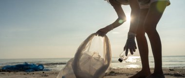 Okyanusu kurtar. Gönüllü olarak plajdaki çöpleri topluyor ve plastik şişeler suda yaşayan canlılara zarar gelmesini engelliyor. Dünya, Çevre, Yeşilci Gezegen, küresel ısınmayı azaltmak, Dünya 'yı kurtarmak