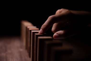 Domino 'yu elleri olan sigorta korur. İş adamı elleri iş krizinde domino taşlarının düşmesini durdurur. işletme risk denetimi ve planlama ve işletmeler sigorta işletmelerini önlemek için stratejiler.