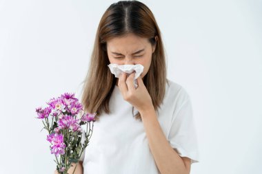 Polen alerjisi, mendile hapşıran Asyalı genç bir kadın veya mendile üfleyerek bahar çiçeklerine ya da bahar çiçeklerine alerjisi olan bir kadın. alerjik reaksiyon, solunum sistemi sorunları