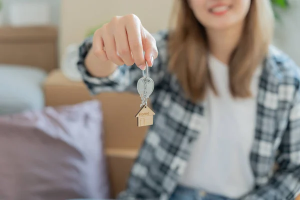 stock image Moving house, relocation. Woman hold key house keychain in new house. move in new home. Buy or rent real estate. flat tenancy, leasehold property, new landlord, dwelling, loan, mortgage.