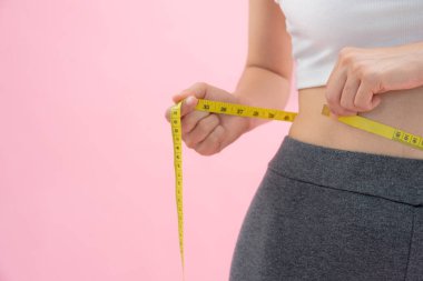 Diyet ve diyet. Güzel, ince kadın vücut ölçüsü. Spor elbiseli bir kadın sağlıklı yaşam için kilo verme hedefine, zayıflığa, ince belliye, beslenme uzmanına ulaşır..