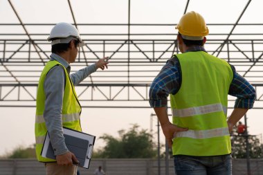 Müfettiş ya da mühendis, inşaat ve kalite güvencesi listesiyle yeni fabrikayı inceliyor. Mühendisler, mimarlar ya da irtibat görevlileri fabrikayı ev sahibine devretmeden önce fabrikayı kurmak için çalışıyorlar.