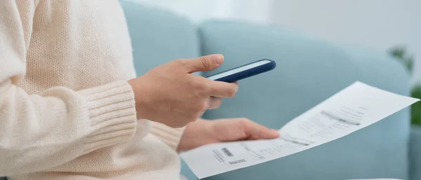 woman use phone scan barcode or QR codes to pay credit card bill after receiving document invoice. payment, receive, paying electricity, digital payments, technology, scanning, financial transactions