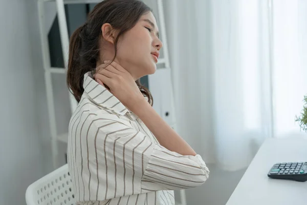 stock image office syndromes, woman massaging neck pain due to work and using a computer, digital composite of a focused spine of neck pain and shoulder pain symptoms , injuries, health care, medical, myositis