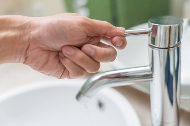 Su tasarrufu. Adam çevreyi korumak için tuvaletteki suyu kapatıp duruyor. Yeşillenen gezegen, küresel ısınmayı azalt Dünya 'yı, yaşamı, geleceği, risk enerjisini, krizi, su gününü kurtar.