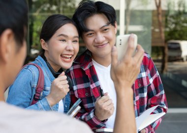 Asyalı güzel bir öğrenci ve arkadaşı sürpriz bir şekilde final sınavına gireceklerini duyurdular. Üniversite kampüsünde mutlu gülümseyen kız. Uluslararası Asya Üniversitesi 'nde kadın portresi. Eğitim, eğitim, okul, mutluluk.