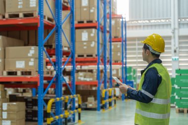 Asian male factory manager inspect goods in warehouse or inventory and check stock product. Transport logistic business shipping, delivery to customers. inspection, storehouse, storage, factory