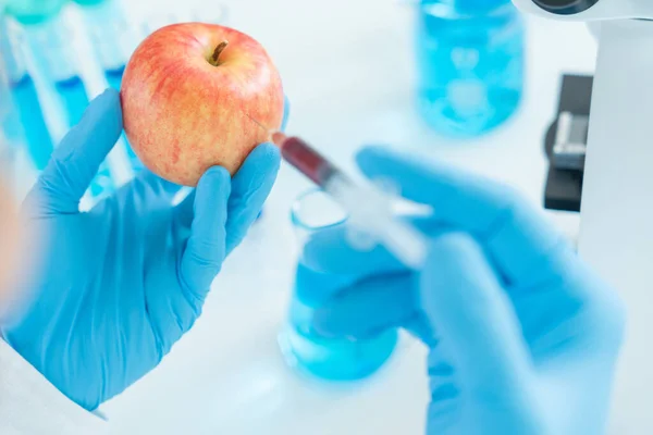 stock image Scientist check chemical food residues in laboratory. Control experts inspect quality of fruit, scientists inject chemicals into apples for experiments, hazards, prohibited substance, contaminate