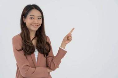 Asyalı güzel bir kızın portresi boş bir alanı işaret ediyor. İş kadını bir şeyi işaret ediyor. Genç bir kadın işaret ediyor. Yan tarafları işaret ediyor. İlan panosu, giriş, reklam.