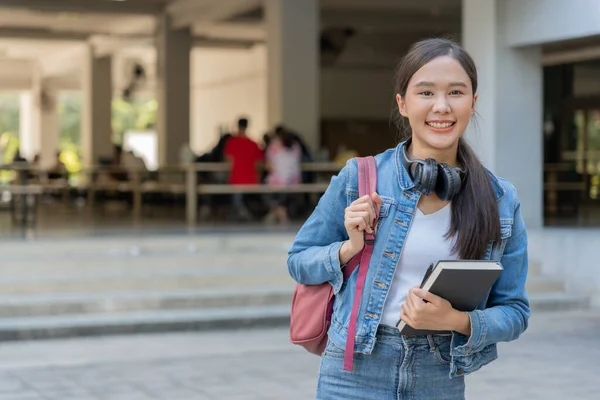 Beautiful student asian woman with backpack and books outdoor. Smile girl happy carrying a lot of book in college campus. Portrait female on international Asia University. Education, study, schoo