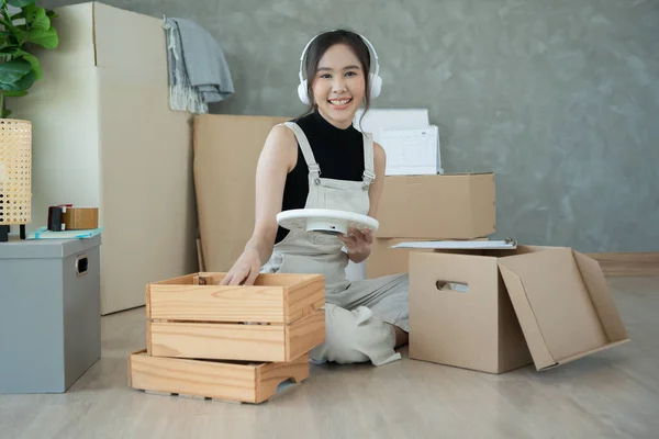 Moving house, relocation. Woman feel good and recreation on new apartment, inside the room was a cardboard box containing personal belongings and furniture. move in the house or condominium