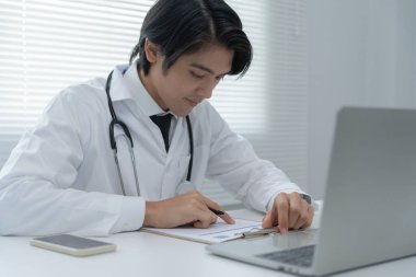 Telemedikal. Doktorlar, hastaların bir röportaj videosunun kaydını tutarlar. Asyalı doktor hastaları telekomünikasyon yoluyla tedavi ederken hastalığı tarif ediyor. Sağlık teknolojisi.