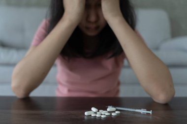 Asyalı kadın aşırı dozda hap kullanıyor, stresli, üzgün, uyuşturucu bağımlısı, hasta, sağlıksız, mutsuz, intihar, depresyon veya ümitsiz, uyuşturucu bağımlısı, yaşam ve aile sorunları, motivasyonsuz