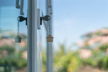 Landlord key for unlocking house is plugged into the door. Second hand house for rent and sale. keychain is blowing in the wind. mortgage for new home, buy, sell, renovate, investment, owner, estat