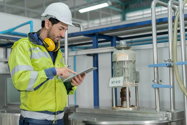 stock image Engineers or factory managers wearing safety helmet inspect the machines in the production line. Utility inspector check machine and test the system to meet the standard. machine, maintenance.