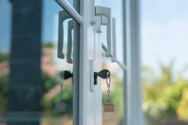 Landlord key for unlocking house is plugged into the door. Second hand house for rent and sale. keychain is blowing in the wind. mortgage for new home, buy, sell, renovate, investment, owner, estate