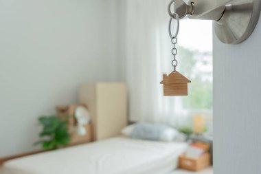 Moving house, relocation. The key was inserted into the door of the new house, inside the room was a cardboard box containing personal belongings and furniture. move in the apartment or condominium