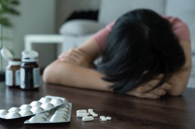 Asyalı kadın aşırı dozda hap kullanıyor, stresli, üzgün, uyuşturucu bağımlısı, hasta, sağlıksız, mutsuz, intihar, depresyon veya ümitsiz, Uyuşturucu bağımlılığı, hayat ve aile sorunları, motivasyonsuz