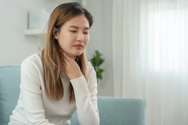 stock image Aisa woman put her hand on her neck due to a sore throat. female tonsillitis causes a inflammation. treated by taking water, taking antibiotics, consult a doctor, virus, corona virus, Influenza, flu