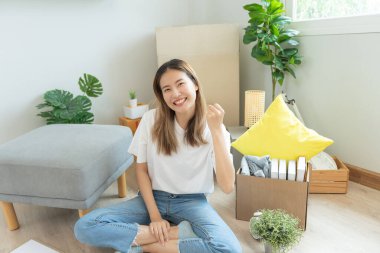 Taşınmak, taşınmak. Kadın kendini iyi hissediyordu ve yeni bir dairede eğleniyordu. Odanın içinde kişisel eşyalar ve mobilyalar olan bir karton kutu vardı. eve ya da apartmana taşın