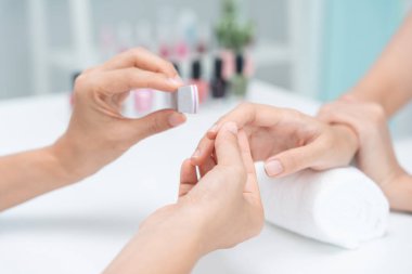 Kadın, güzellik merkezinde profesyonel güzellik manikürü ile bakım hizmeti alıyor. Güzellik salonunda jöle tedavisi için tırnak törpüsü kullanın. Manikürcü, çivi müşterisini güzelleştirir. vücut bakımı spa tedavisi