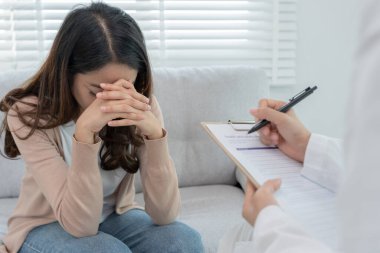 Akıl sağlığı sorunları olan bir kadın danışmanlık yapıyor. Psikiyatrist tedavi için hastanın durumunu kaydediyor. teşvik, sevgi ve aile sorunu, bipolar, depresyon hastası, intiharı koru