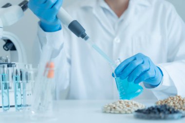 Bilimadamı laboratuvardaki tüm kimyasal tanecikleri kontrol ediyor. Kontrol uzmanları kimyasal kalıntıların konsantrasyonunu inceliyor. Tehlike, standart, yasaklı maddeler, kirlilik, mikrobiyoloji