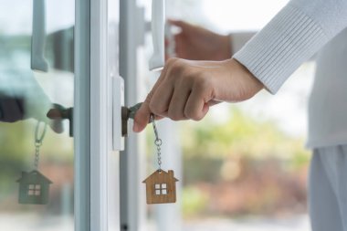 Landlord key for unlocking house is plugged into the door. Second hand house for rent and sale. keychain is blowing in the wind. mortgage for new home, buy, sell, renovate, investment, owner, estate