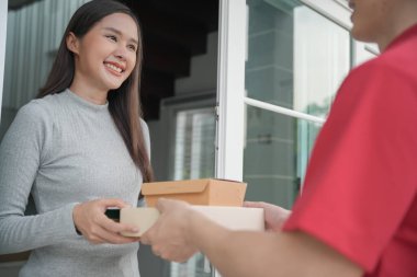 Mutlu gülümseyen kadın evdeki kuryeden kutuları alıyor. Teslimatçı ekspres teslimat gönderdi. Online alışveriş, kağıt konteynırlar, paket servisi, postacı, teslimat servisi, paketler.