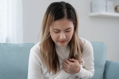 Göğüs kafesinde kalp krizi belirtileri var. Asyalı kadınlarda göğüs ağrısı var. Kalp rahatsızlığı, sızıntı, genişleme, genişlemiş kalp, göğse acı verici bir ifadeyle bastırma.