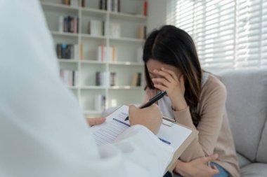 Akıl sağlığı sorunları olan bir kadın danışmanlık yapıyor. Psikiyatrist tedavi için hastanın durumunu kaydediyor. teşvik, sevgi ve aile sorunu, bipolar, depresyon hastası, intiharı koru