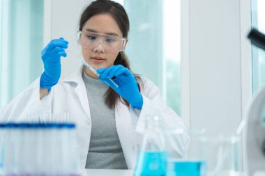 Bilimadamı ileri bilimsel laboratuvarda biyokimyasal örnekleri analiz ediyor. Tıbbi profesyonel kullanım düşürücü mikrobiyolojik virüs gelişimini karıştırıyor. Fen laboratuvarında biyoteknoloji araştırması. cosmeti