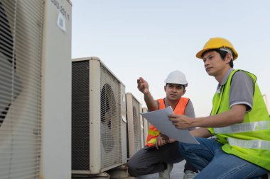 Engineers use blueprint check air condition systems on site. Contractor and inspector inspection compressor during project. maintenance team check quality assurance. Audit, inspect, quality control.
