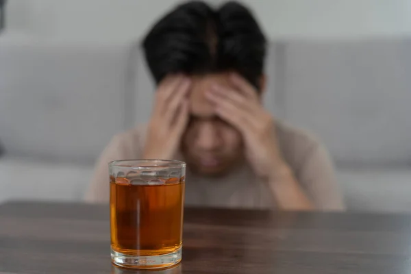 stock image Depressed young Asian man addicted feeling bad drinking whiskey alone at home, stressed frustrated lonely drinking alcohol suffers from problematic liquor, alcoholism, life and family problems