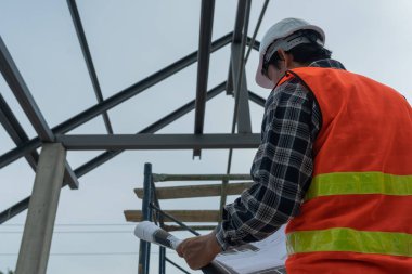 Müfettiş ya da mühendis mavi baskı kullanarak inşaat ve kalite güvencesini denetliyor. Mühendis, mimar ya da irtibat kurucu ev sahibine teslim etmeden önce evi inşa etmek için çalışır.