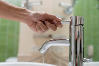 Save water. Volunteer keeps turning off the running water in the bathroom to protect environment. Greening planet, reduce global warming, Save world, life, future, risk energy, crisis , water day.