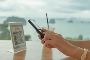 Woman use smartphone to scan QR code for order menu in cafe restaurant with a digital delivery. Choose menu and order accumulate discount. E wallet, technology, pay online, credit card, bank app.