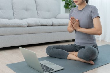 Sıska kadın evinde ya da dairesinde yoga yapıyor. Sabahları egzersiz yapan Asyalı bir kadın. denge, meditasyon, rahatlama, sakinlik, sağlık, mutluluk, rahatlama, sağlıklı yaşam tarzı, diyet, sli