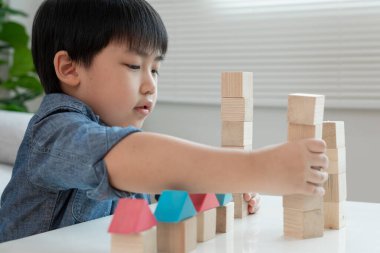 Oynayan ve oyuncak blokları öğrenen mutlu Asyalı çocuk. Çocuklar evde çok mutlu ve heyecanlı. Çocuk oyun, etkinlik, gelişme ve dikkat eksikliği hiperaktivite bozukluğuyla çok iyi vakit geçiriyor