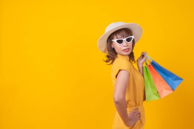 Modern mutlu Asyalı kadın moda portresi. Güzel, çekici, genç bir kız alışveriş merkezinde şık kıyafetler ve alışveriş torbalarıyla şık yürüyüşler yapıyor.