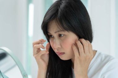 Young woman are worried about faces Dermatology and allergic to steroids in cosmetics. sensitive skin, red face from sunburn, acne, allergic to chemicals, rash on face. skin problems and beauty