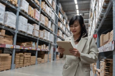 Fabrika müdürü depodaki malları ya da stok ürünlerini inceler ve kontrol eder. Lojistik ticaret nakliyesi, müşterilere teslimat. Denetleme, depo, depo, fabrika,