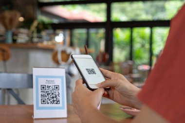 Kadın, kafeterya restoranında sipariş menüsü için dijital dağıtım ile QR kodunu taramak için akıllı telefon kullanıyor. Menüyü ve siparişi seçin ve indirimi toplayın. E cüzdan, teknoloji, online ödeme, kredi kartı, banka uygulaması.
